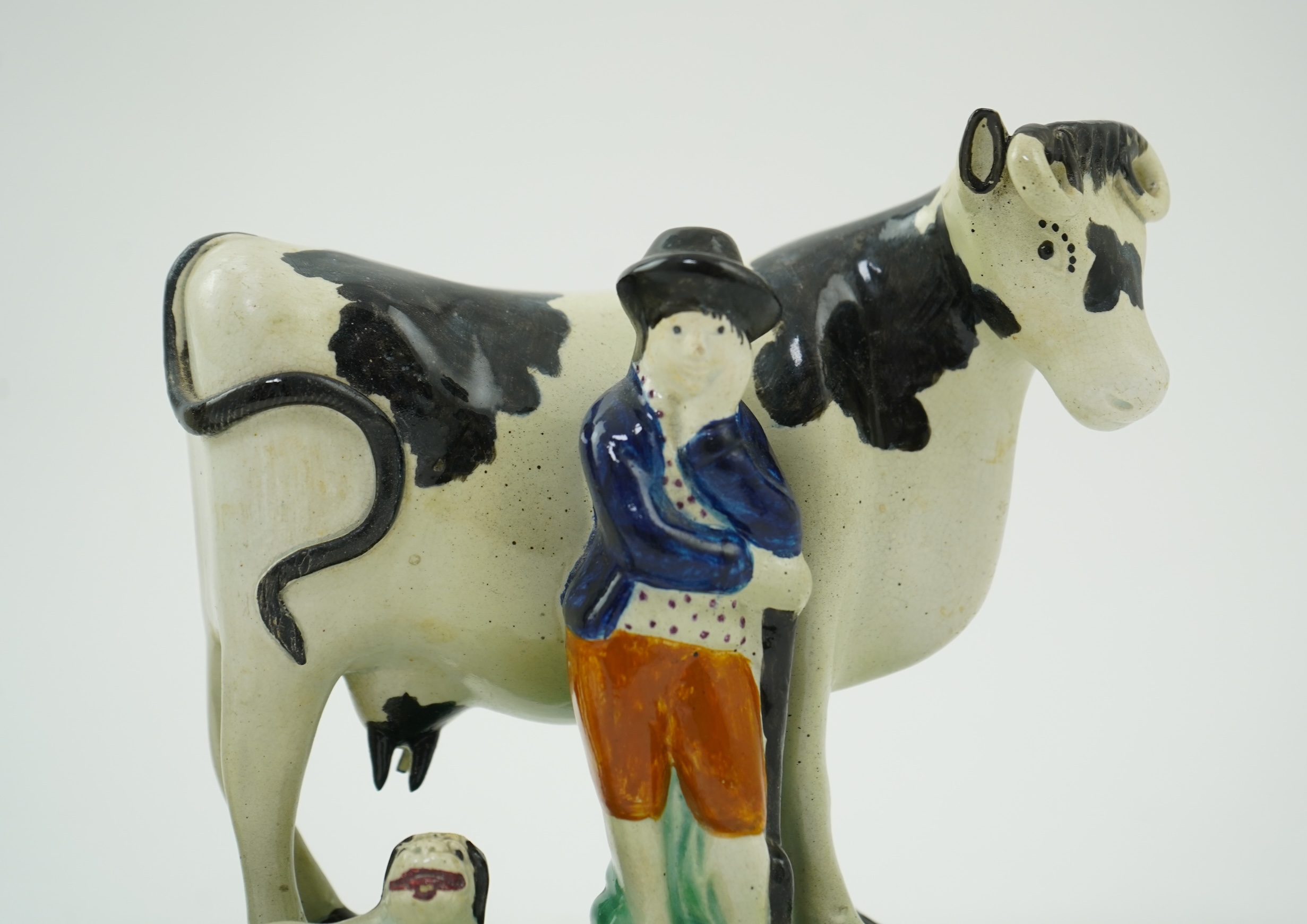 Two Yorkshire Prattware cows, with farmer or milkmaid and dog groups, c.1810